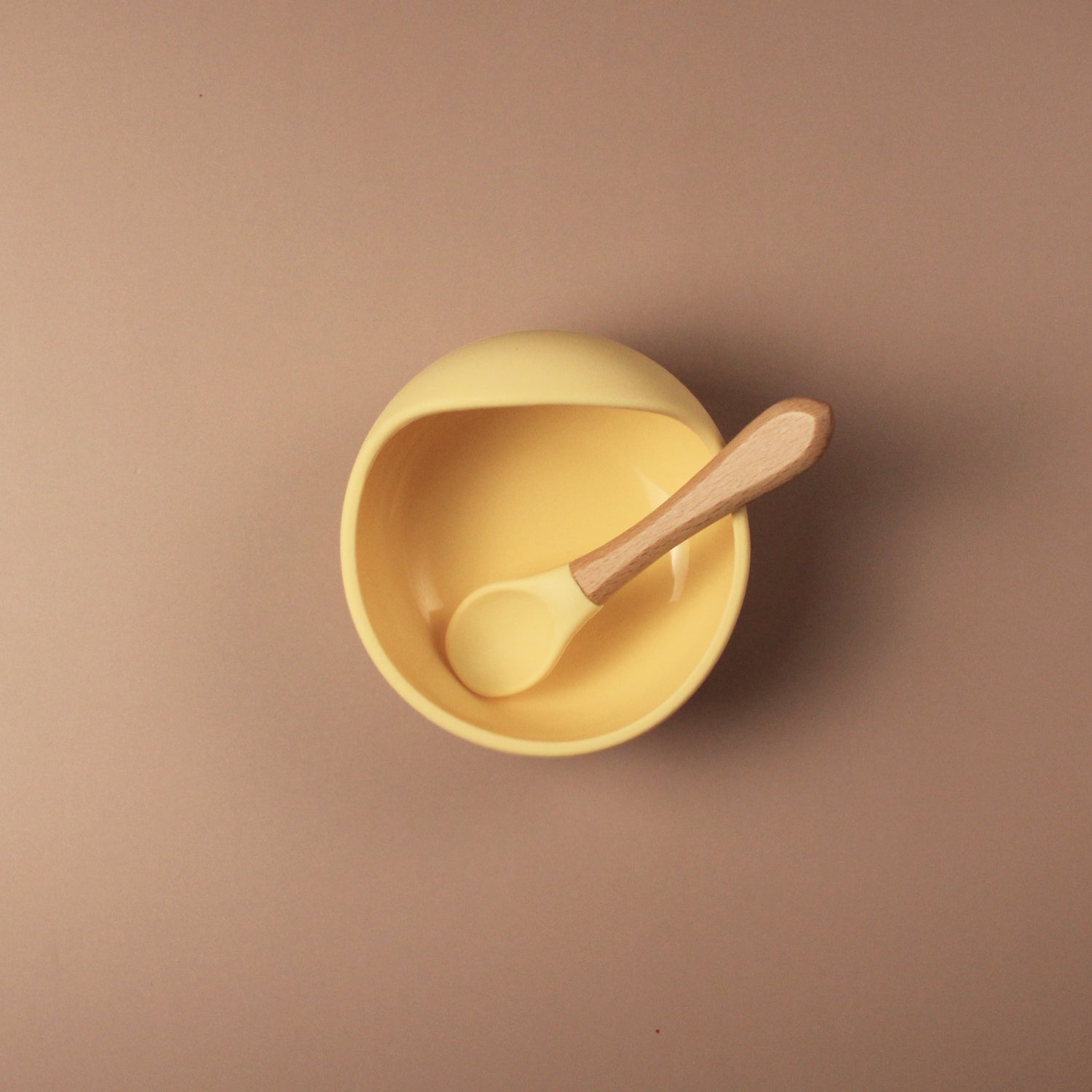 baby feeding silicone suction bowl in yellow, with matching wooden handle spoon